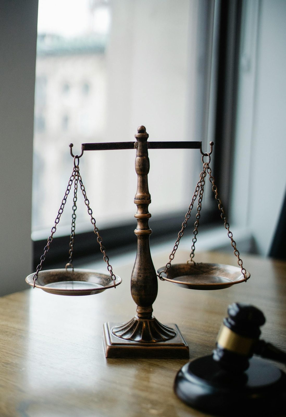 Balanza de la justicia junto a una ventana